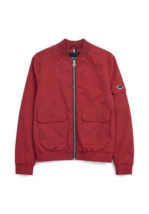 Chaqueta bomber roja con cremallera frontal, dos grandes bolsillos con solapa, puños y dobladillo elásticos, y un pequeño parche en la manga izquierda.