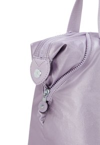 Light purple nylon bag with a smooth texture, featuring a zipper closure and a round, silver-toned button detail on the side.
