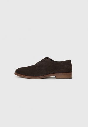 Bruine suede oxford schoen met een ronde neus, vijf veterogen, contrasterende naden en een lage gestapelde hak. Soepele textuur en klassiek ontwerp.