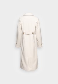 Licht beige jas van een wollen mix met een reverskraag, twee goudkleurige knopen aan de achterkant en lange mouwen met knoopaccenten.