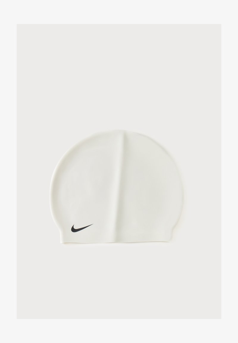 Бяла силиконова шапка за плуване с малко черно лого Nike swoosh отпред отляво, показана на едноцветен фон.