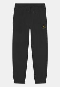 Mustat collegehousut pehmeästä kankaasta, joissa on joustava vyötärönyöri ja pieni keltainen Jordan-logo vasemmassa reidessä.