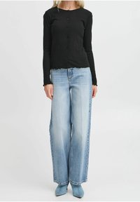 Černý žebrovaný dlouhý rukáv s knoflíky, spárovaný s světle modrými širokými džíny a modrými lodičkami s špičatou špičkou, s cropped lemem.