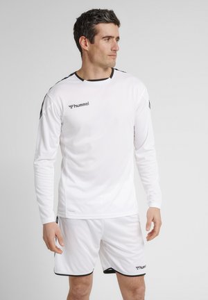 Weißes Langarm-Sportshirt mit schwarzen Akzenten, kombiniert mit passenden Shorts, die einen strukturierten Stoff und ein Logo auf der Brust und den Shorts aufweisen.
