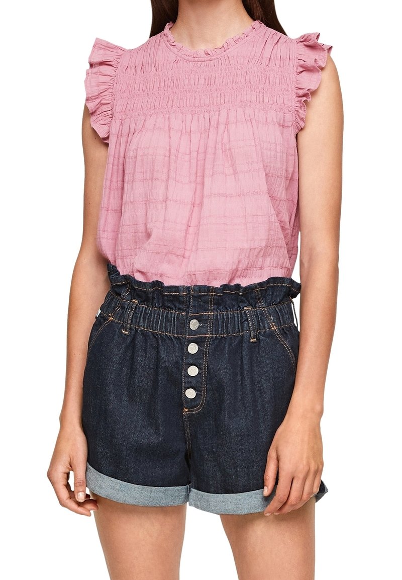 Haut court rose avec manches à volants, texture froncée ; associé à un short en denim foncé, taille élastique, boutons sur le devant, ourlets retroussés.