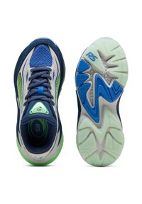 Scarpe sportive blu e verdi con tomaia in mesh e suole dettagliate, una scarpa mostra la vista dall'alto e l'altra mostra la suola.