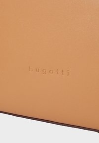 Tan leren product met een gladde structuur, voorzien van een geperst "bugatti" logo. Het ontwerp bevat een contrasterende donkere rand.