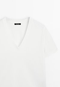 Weißes Baumwoll-T-Shirt mit V-Ausschnitt, kurzen Ärmeln und glatter Textur. Etikett am Halsbereich sichtbar.