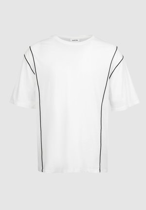 Baltas kokvilnas T krekls ar melniem diegiem gar šuvēm. Tam ir apaļa kakla izgriezums un īsas piedurknes, un tas ir brīvā piegriezumā.