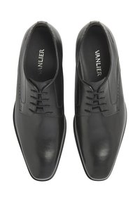 Zwarte leren schoenen met een gladde afwerking, ronde neus, traditionele vetersluiting en minimale decoratieve stiksels.