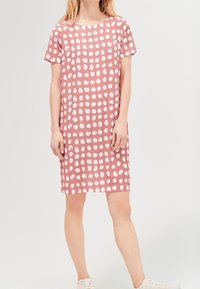 Vestido de manga corta, hasta la rodilla, en un suave color rosa claro con lunares blancos, que cuenta con un escote redondo y un corte holgado. Material de algodón suave.