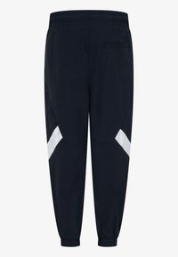 Námorné jogger nohavice s bielymi diagonálnymi pruhmi, elastickým pásom, zúženými manžetami a jednou zadnou vreckom. Hladká textúra, ľahká tkanina.