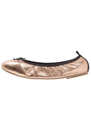 Rose gold ballet flat made of shimmery metallic leather with a black elastic trim and bow accent on the toe. Slightly cushioned insole.