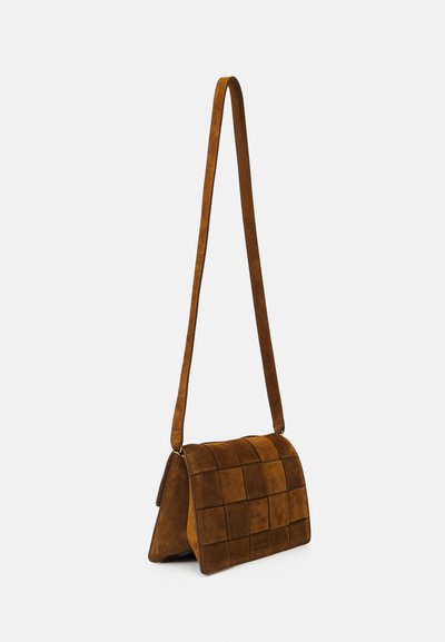 Bolso crossbody de ante marrón con un diseño acolchado, correa ajustable y cierre de solapa. Presenta una textura suave y forma rectangular.