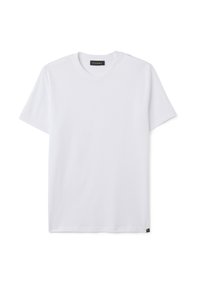 T-shirt bianco a manica corta con collo rotondo, con un piccolo etichetta nera sull'orlo inferiore e un'etichetta del brand all'interno del colletto.