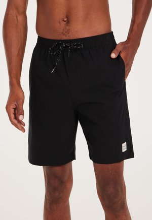 Schwarze Badeshorts aus leichtem Material, mit einem elastischen Bund und einer Kordel zum Verstellen sowie einem kleinen Logo-Patch am Saum.