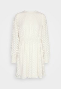 Vestido blanco con mangas largas, cinturilla elástica y patrón en forma de chevrón. Textura suave, escote redondeado y corte relajado.
