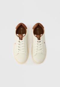 Para kremowych sneakersów z brązowymi skórzanymi detalami i białymi sznurowadłami, rozmiar 36, widocznych z góry na białym tle.