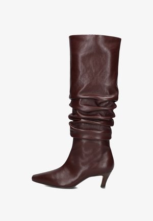 Brown leather knee-high boot with slouchy upper, pointed toe, and a small angled heel. Smooth texture with a glossy finish.