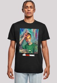 Camiseta negra con un gráfico colorido de un personaje con la mano levantada a la frente. El texto debajo dice "The Big Bang Theory."