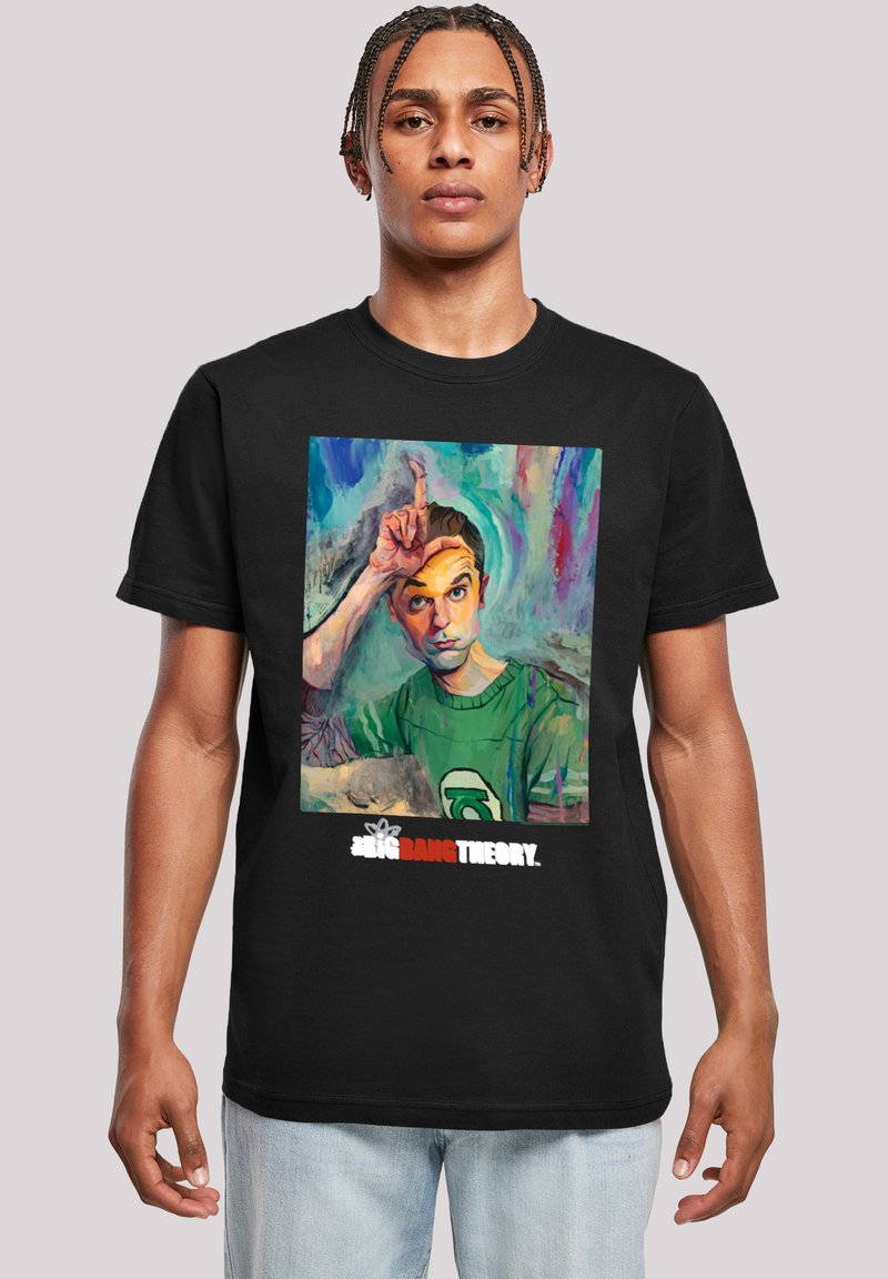 Camiseta negra con un gráfico colorido de un personaje con la mano levantada a la frente. El texto debajo dice "The Big Bang Theory."