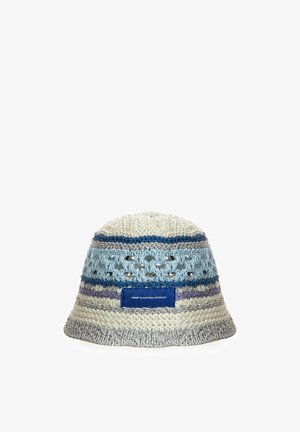 Sombrero tipo bucket de ganchillo con rayas blancas, azules y grises y una etiqueta azul en la parte delantera, con detalles de punto abierto cerca de la parte superior.