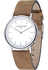 Montre ronde en argent avec un cadran blanc et des index noirs minimalistes. Bracelet en cuir brun avec une texture lisse et des détails de couture.