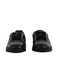 Zapatillas de cuero negro con un acabado suave, punta redonda, detalles perforados y cordones negros, con una suela acolchada.