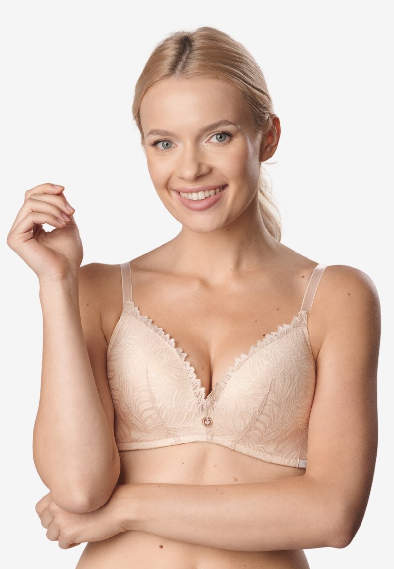 Jasnobeżowy stanik koronkowy o głębokim dekolcie, ze falbaniastymi krawędziami i cienkimi, przezroczystymi ramiączkami. Posiada mały ozdobny pierścień na środku.