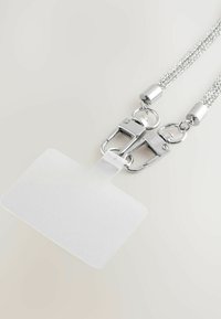 Tomt hvidt vandret ID-badgeholder fastgjort til en sølvglitrende lanyard med to metalclips på en lys baggrund.