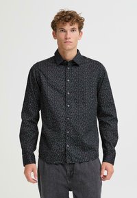 Camicia nera con bottoni, adornata da un piccolo motivo floreale multicolore. Caratterizzata da maniche lunghe e un design del colletto classico. Texture liscia.