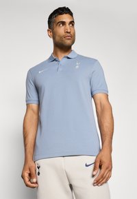 Lyseblå polo t-shirt lavet af bomuld, med krave, placket med tre knapper og broderet logo. Kombineret med lysegrå sweatpants.