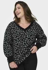 Pulover cu imprimeu de leopard în culorile negru și gri, cu decolteu în V, mâneci ribbed și croială lejeră. Fabricat dintr-un material moale, tricotat.