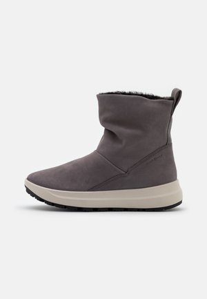 Bottine imperméable grise avec une tige texturée douce, une doublure chaude, un design lâche et une semelle claire contrastante avec un motif rainuré.