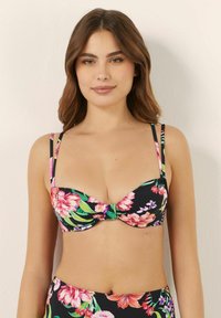 Blommig bikiniöverdel med svart bakgrund, rosa och gröna blommönster, bygelstöd och tunna justerbara band.