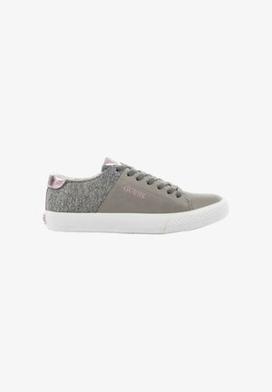 Baskets basses grises en tissu texturé avec semelle blanche, lacets gris, languette de talon métallique rose, et logo "GUESS" rose sur le côté.