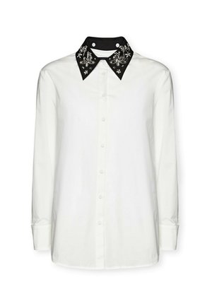 Camicia bianca a maniche lunghe con colletto nero e decorato, caratterizzata da motivi floreali decorativi e chiusura frontale con bottoni.