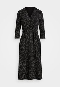 Svart omlottklänning med trekvartsärmar, som har ett vitt och krämfärgat abstrakt mönster, knytmidja och en medellång nederkant.