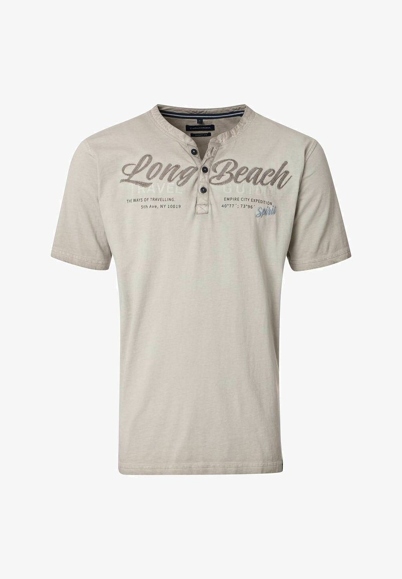 Jasno beżowa koszulka z krótkim rękawem wykonana z bawełny. Posiada trzy guzikową listwę i nadrukowany tekst, w tym "Long Beach" w ciemnym brązie.