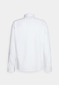 Biała koszula z długim rękawem wykonana z bawełny, z klasycznym kołnierzykiem, zapinanymi na guziki mankietami i prostym dołem o minimalnej fakturze.