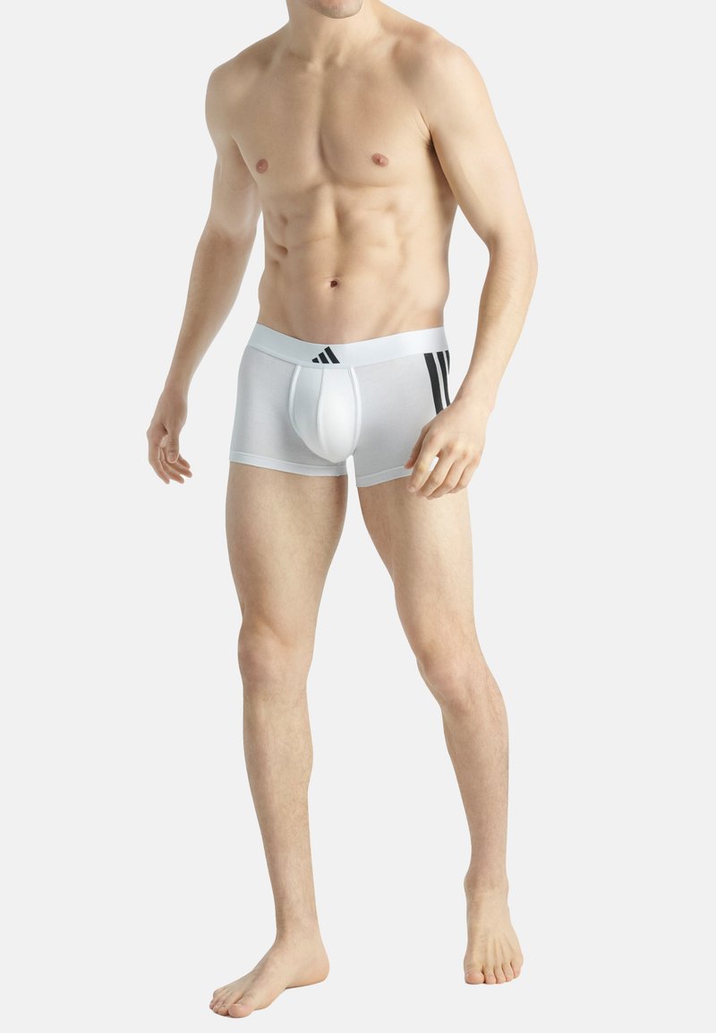 Vita boxerkalsonger med en åtsittande design, som har en formad ficka, elastiskt midjeband och tre svarta ränder på vänster sida.