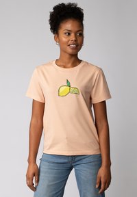 Perzikkleurig katoen t-shirt met een ronde hals, korte mouwen, met een grafisch ontwerp van een hele citroen en een citroenschijfje met groene bladeren.