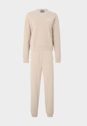 Ensemble sweat-shirt et jogger beige en tissu doux. Le sweat-shirt présente un col rond et des poignets côtelés ; les joggers ont une taille élastique.