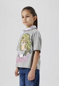 Grå kortärmad t-shirt med en grafisk tryck av en karaktär med blont hår och ordet "bored" i rosa. Matchad med blå jeans.