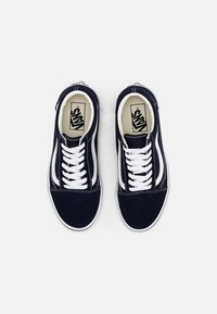 Marineblaue Segeltuch-Sneaker mit weißen Akzenten, im Low-Top-Design, weißen Schnürsenkeln und kontrastierenden Nähten. Einfache Gummisohle.