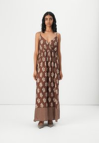 Robe maxi marron avec des motifs de feuilles, décollet�ée en V et bretelles réglables ; possède une jupe évasée avec un motif en zigzag contrastant sur l'ourlet.