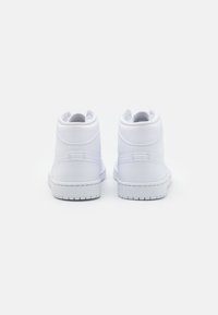 Bílé vysoké tenisky s hladkým koženkovým svrškem, polstrovaným límcem a texturovanou gumovou podrážkou. Minimalistický design bez viditelných log.