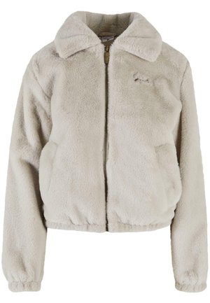 Lysbeige zip-up faux fur jakke med krave, elastisk kant, sidelommer og diskret logo på brystet.