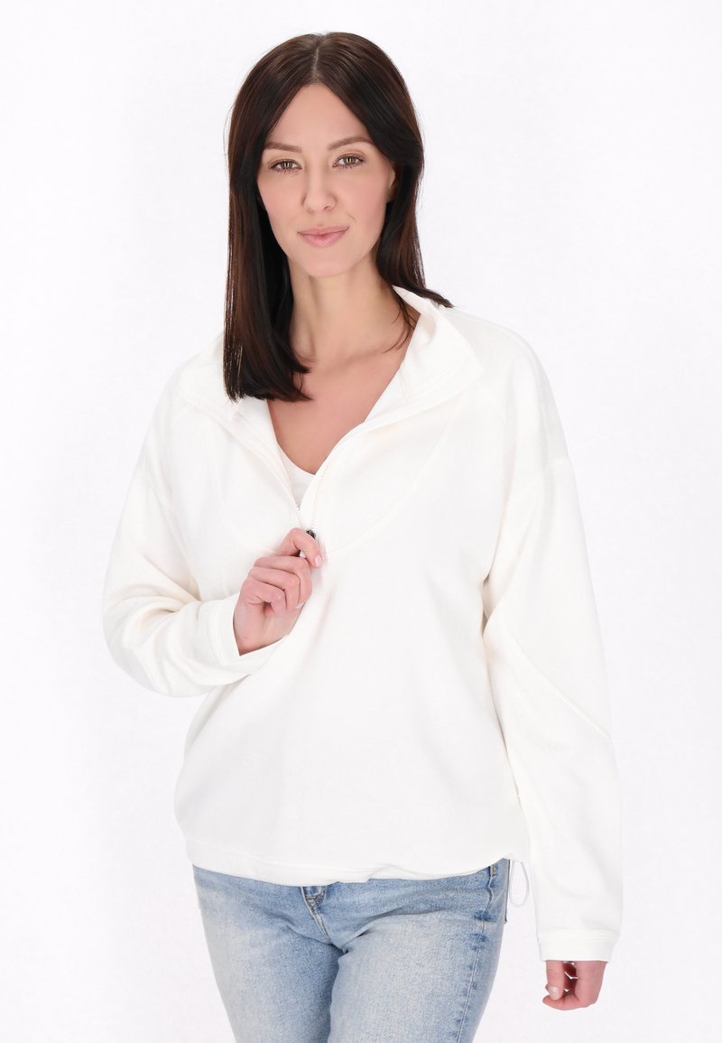 Giacca bianca a pullover con mezza zip frontale, maniche lunghe e vestibilità rilassata. Tessuto morbido con una texture liscia e dettagli di design minimi.