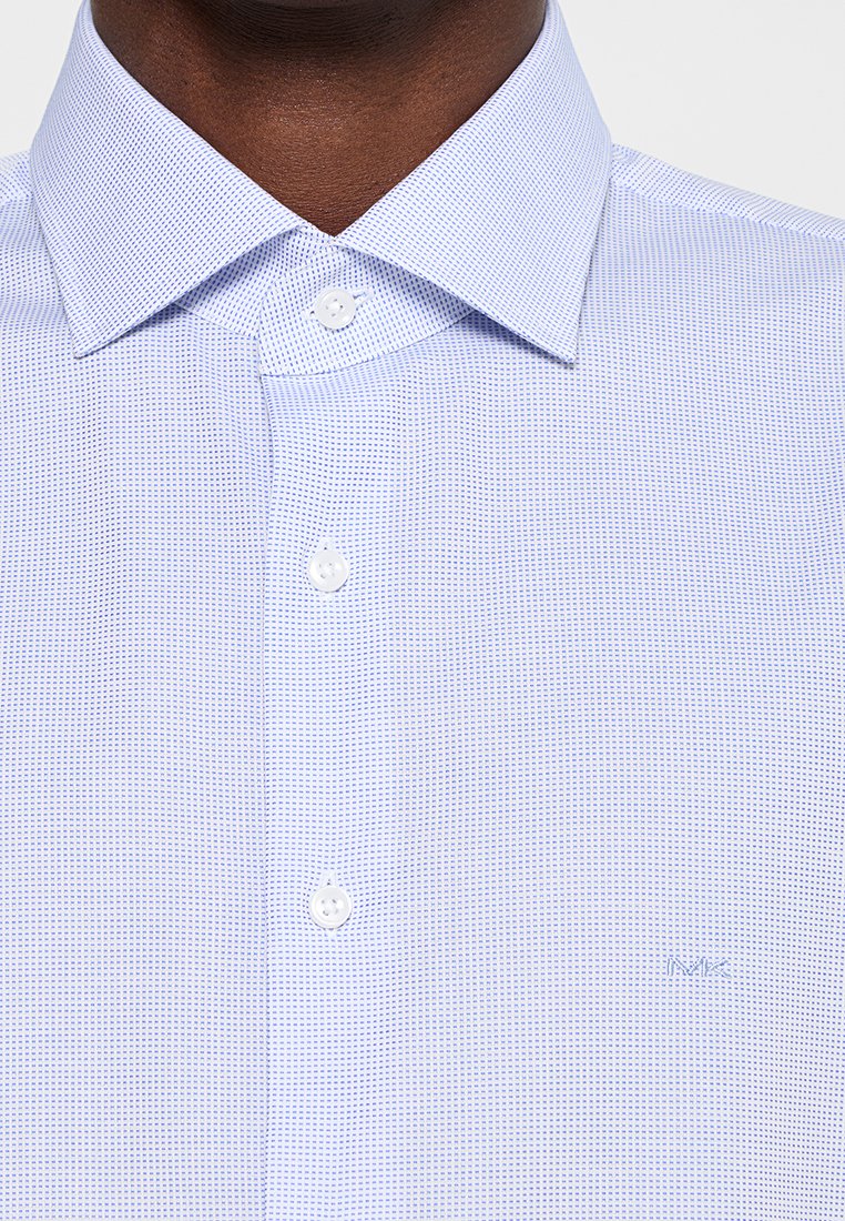 Camisa a cuadros azul claro hecha de algodón, con un collar puntiagudo, botones blancos y un sutil logotipo de la marca bordado cerca del dobladillo.